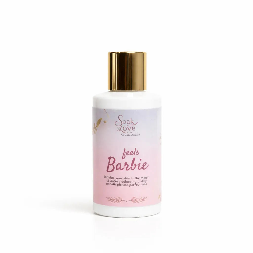 Bottle of Soak in Love Feels Barbie Brightening Body Lotion with a pink and white label and gold cap for daily skin hydration and radiance.