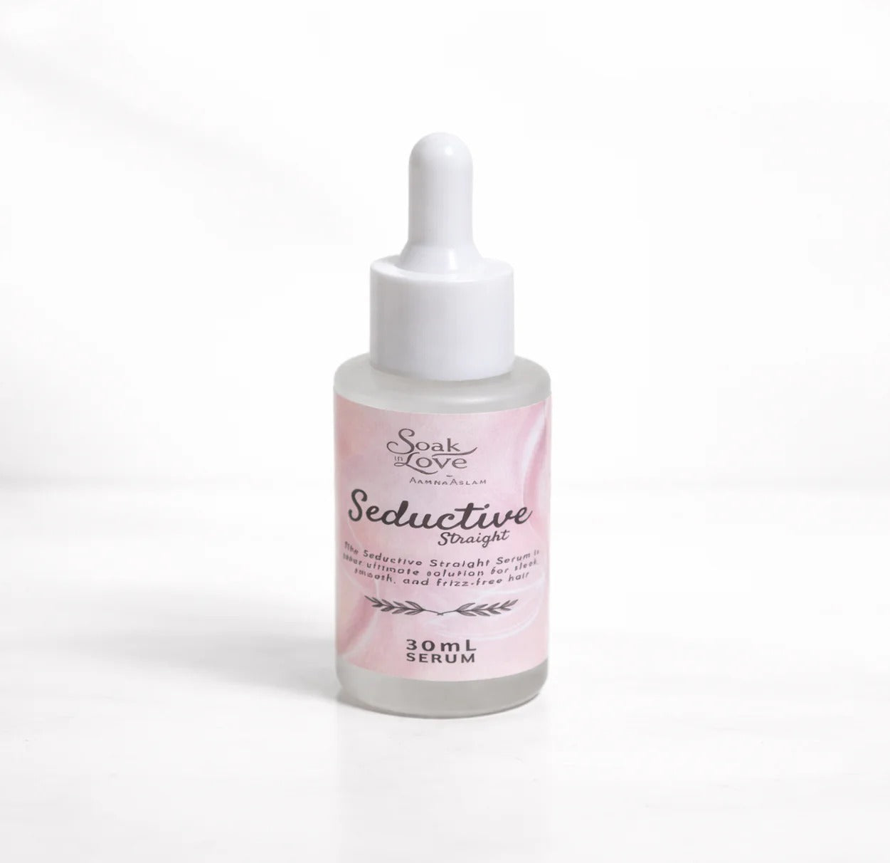 Hands holding a bottle of Soak in Love Seductive Starlight Face Serum 30ml with a glass dropper dispensing a clear serum for glowing and hydrated skin.